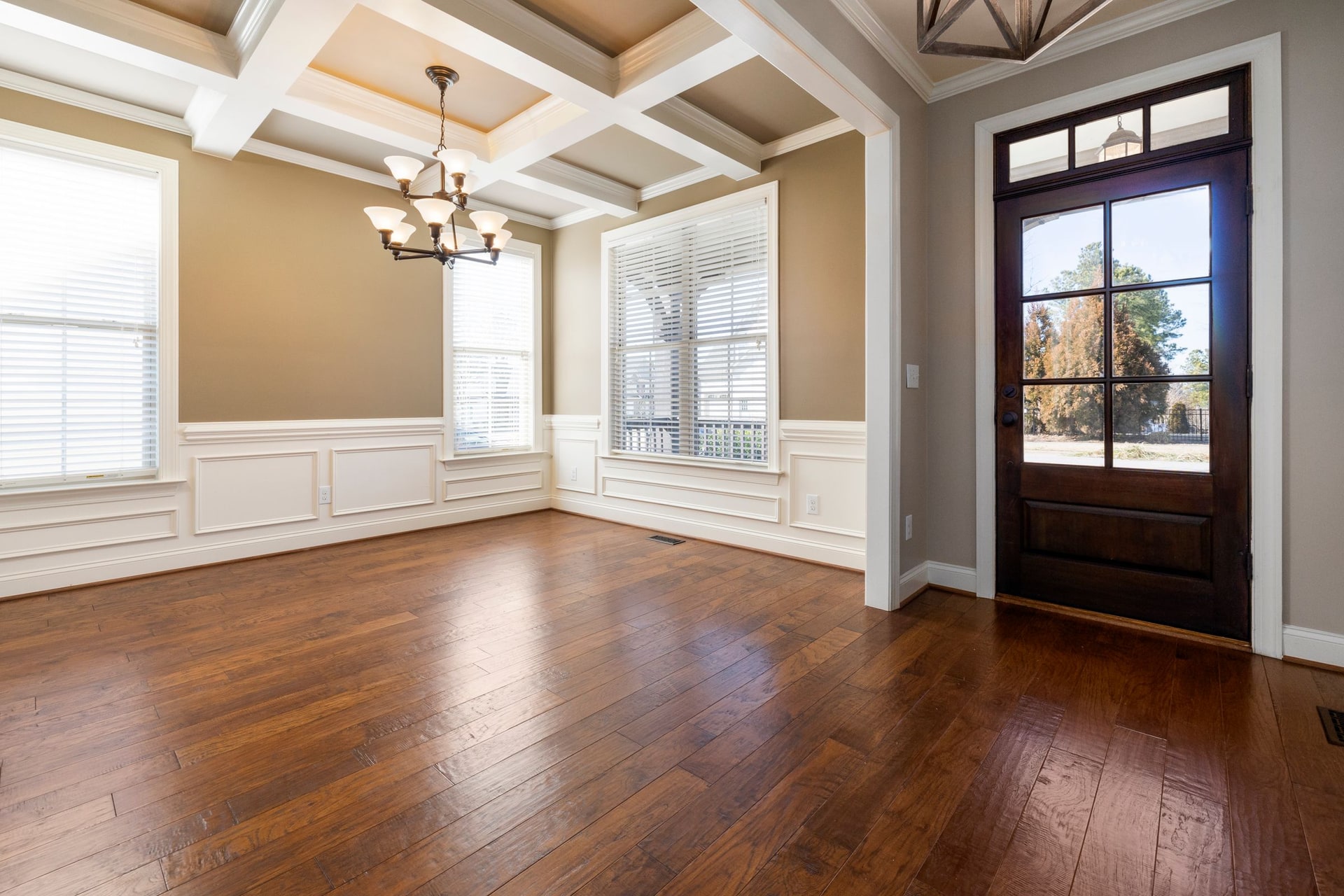 Warm hickory hardwood flooring running through a bright entry and living space
